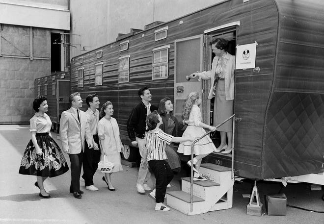 FILE - In this Aug 20, 1957, file photo, Walt Disney's Mouseketeers enter a large trailer that serves as their school on the Disney lot in Hollywood, Calif. Greeting them is their teacher Jean Seaman of the Los Angeles Public School System. Jimmy Dodd, red-haired and fortyish, is master of Mouseketeer ceremonies. Mouseketeer Annette Funicello can be seen at far left. Police have confirmed that a body found in April 2019 at an Oregon home is that of missing man Dennis Day, who was an original member of Disney's "The Mickey Mouse Club." (AP Photo/Ernest K. Bennett, File)