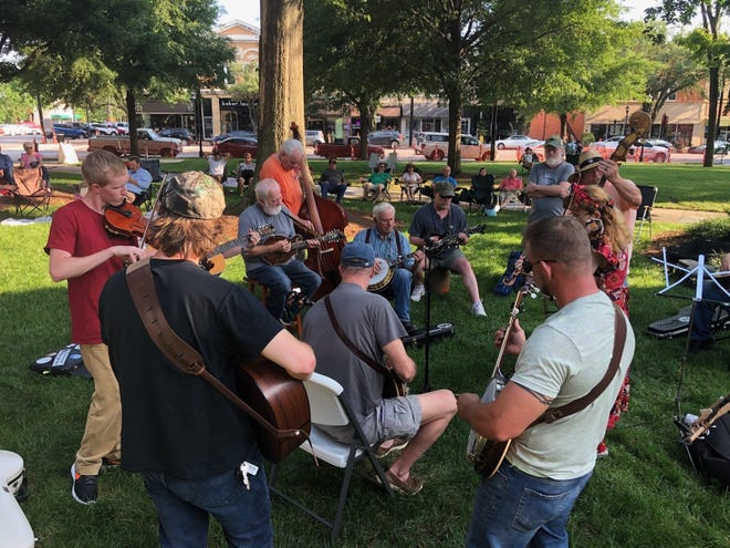 Musicians gather during Pickin' On The Square events to play string instruments on the lawn outside the Earl Scruggs Center. [Special to The Star]