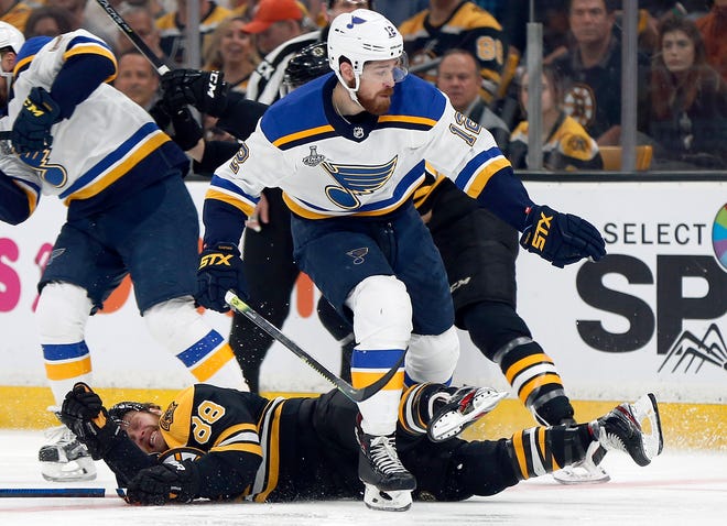 St. Louis Blues' Zach Sanford (12) checks Boston Bruins' David Pastrnak (88), of the Czech Republic, to the ice during the first period in Game 5 of the NHL hockey Stanley Cup Final, Thursday, June 6, 2019, in Boston. (AP Photo/Michael Dwyer)