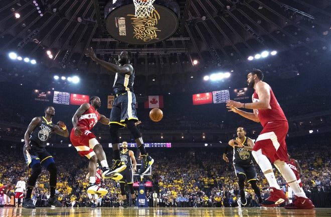 Toronto's Kawhi Leonard gets Golden State defender Draymond Green up in the air and then passes to teammate Marc Gasol under the basket in Friday's victory. Leonard has been doing it all for the Raptors and is looking like an NBA Finals MVP again. [Frank Gunn/The Canadian Press]