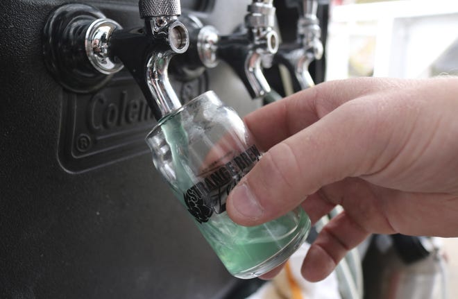 In this photo taken May 18, 2019, a blue raspberry jolly rancher sour beer is poured at the Strange Brew Festival in Reno, Nev. As craft breweries have boomed, competition for attention has intensified and that has a lot of brewers looking for ways to differentiate themselves by introducing strange new flavors. (AP Photo/Haven Daley)