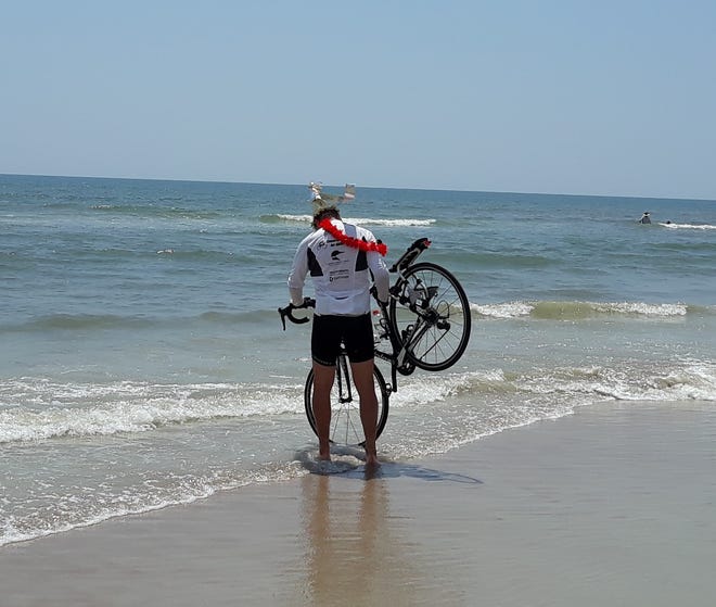 Following a bike ride from San Diego to St. Augustine, cyclist Chris Dieringer dips his front tire into the Atlantic Ocean. (Courtesy photo)
