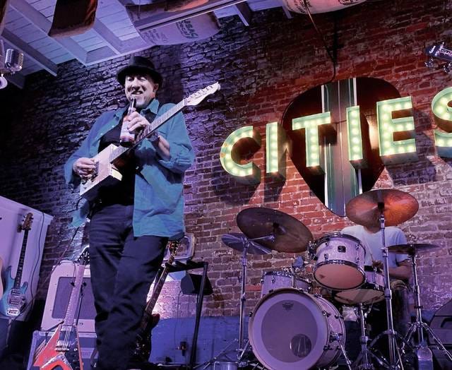 Using a Budweiser beer bottle, Stacy Mitchhart rips a sliding blues solo on his cigar box guitar at CITIES in Columbia on Saturday. (Staff photo by Jay Powell)