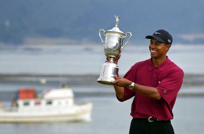 In this June 18, 2000, photo Tiger Woods holds the trophy after capturing the 100th U.S. Open Golf Championship at Pebble Beach. For all his feats, nothing compares with Woods' 15-shot victory at Pebble Beach that year, the largest margin in major championship history. [AP Photo/Elise Amendola, File]