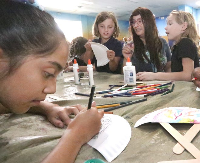 Emily Orozco, a Flagler Palm Coast high school senior nearing graduation, works an art project with Ashlyn Mayberry, left, Sarah Garcia, right, and Selena Miranea, foreground, Tuesday, May 14, 2019 in the after school program at Old Kings Elementary.  [News-Journal/David Tucker]