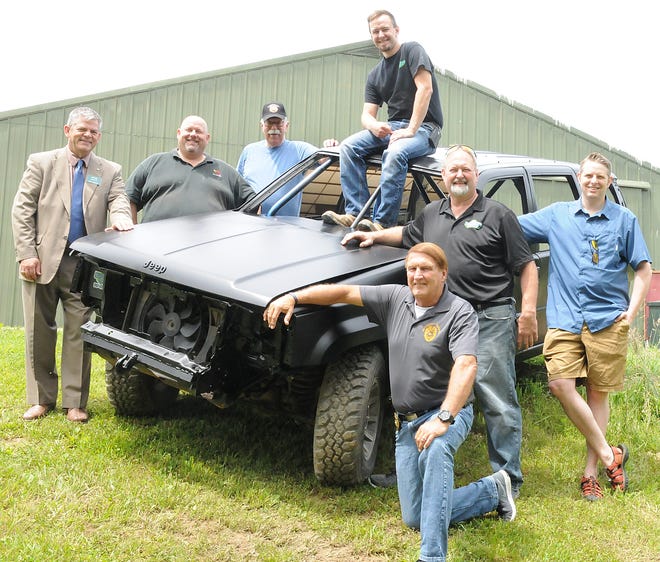 Matt Daymut sits high on his ruff truck he'll be using to compete with Saturday evening during the Cambridge Lions Club's 5th annual Ruff Truck competition at the Guernsey County Fairgrounds. Lions Pictured from left front, John Davis, Gary Daymut, Joel Blue; back, Steve Marvin, Brad Richert and John White.