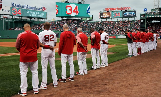 The Boston Red Sox and fans pause for a moment for former Red Sox designated hitter David Ortiz, who was shot Sunday evening in the Dominican Republic, prior to a baseball game against the Texas Rangers at Fenway Park in Boston, Monday, June 10, 2019. Ortiz is expected to return to the area to be treated at a Boston hospital. (AP Photo/Charles Krupa)