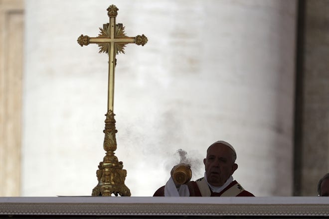 Pope Francis is silhouetted as he spreads incense on the altar during a Pentecost Mass in St. Peter's Square, at the Vatican, Sunday. The Vatican issued an official document Monday rejecting the idea that people can choose or change their genders and insisting on the sexual "complementarity" of men and women to make babies. [GREGORIO BORGIA/ASSOCIATED PRESS]