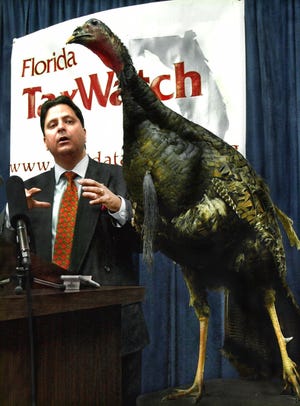 Florida TaxWatch President Dominic Calabro uses a stuffed turkey as a visual aid to illustrate his point that lawmakers produce too many "budget turkeys," while commenting at a news conference in Tallahassee. [AP Photo/Mark Foley, File]
