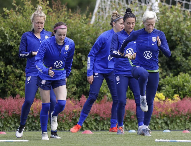 US player Megan Rapinoe, front right, stretches with Ali Krieger and other team members during a US womens soccer team training session at the Tottenham Hotspur training centre in London, Thursday. The United States will face Thailand in their World Cup opener today in Reims, France. [The Associated Press / Kirsty Wigglesworth)
