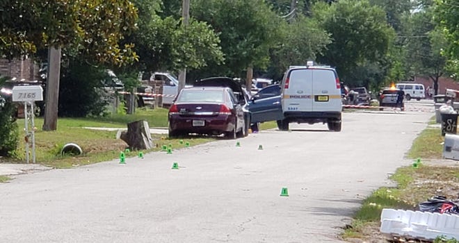 Multiple evidence markers dot Luke Street, where spent shells indicate gunfire that killed a young man who was shot in the head early Tuesday on Jacksonville's Westside. [Dan Scanlan/Florida Times-Union]