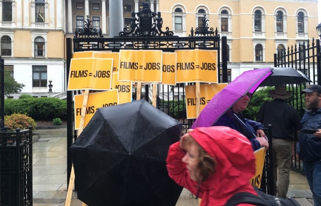 "Films = Jobs" signs were piled around the State House's Ashburton Park entrance in the drizzle Tuesday morning ahead of a hearing on Rep. Tackey Chan's bill to permanently extend the film tax credit. [Photo: Sam Doran/SHNS]