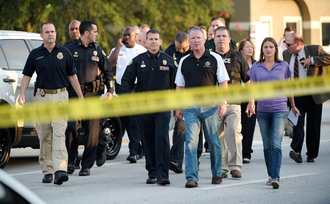 FILE - In this Sunday, June 12, 2016 file photo, Mayor Buddy Dyer, center right, and then-Police Chief John Mina, center left, arrive for a news conference after the mass shooting at the Pulse Orlando nightclub in Orlando, Fla. Mina, now the Orange County, Fla., sheriff, says after the attack, police officers were equipped with another layer of body armor that stops rifle rounds. (AP Photo/Phelan M. Ebenhack)