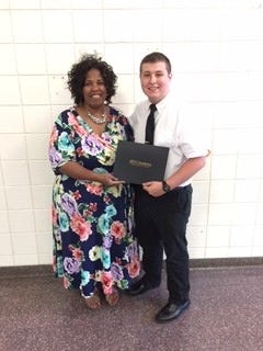 Alison Clark, board member with the State Employee Credit Union, presents a $10,000 scholarship to Caleb Mayes. [Special to The Star]
