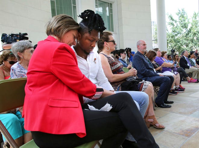Jennifer Foster, executive director of the One Orlando Alliance, embraces Pulse survivor Joshua Lewis, during the tolling of the bells and the reading of victims' names, at First United Methodist Church in Orlando on Wednesday, the 3rd anniversary of the Pulse nightclub massacre. [Joe Burbank/Orlando Sentinel via AP]