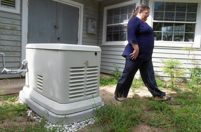 Coral Landing assisted living facility administrator Karen Cannon walks beside her facility's emergency generator in 2018. [PETER WILLOTT/THE RECORD]