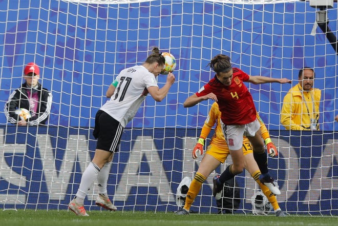Germany's Alexandra Popp, heads the ball against Spain's Irene Paredes, right, and Spain goalkeeper Sandra Panos, background, before teammate Germany's Sara Daebritz scored the opening goal during the Women's World Cup match between Spain and Germany at Stade du Hainau in Valenciennes, France on Wednesday. [Michel Spingler/Associated Press]
