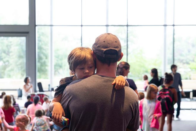 Elias Romo, 3, rests on his father's shoulder following the Austin Symphony Children's Day Art Park at the Austin Central Library on Wednesday, June 20, 2018. The Allrhythms Percussion Ensemble and the Austin Symphony Orchestra String Quartet performed during a reading of a children's book, and afterward, families participated in crafts and played instruments together.