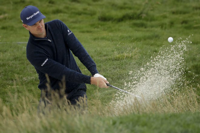 Justin Rose hits out of a bunker on the 17th hole during the second round of the U.S. Open on Friday. Rose topped the early group at 7-under-par 135. [Marcio Jose Sanchez/The Associated Press]