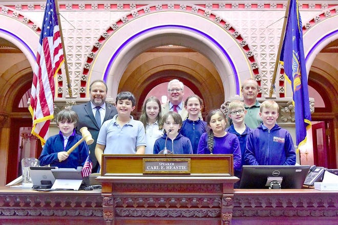 From left to right in the back row, Assemblyman Phil Palmesano, Senator Tom O'Mara and teacher Keith Prather join the fifth grade students from St. Michael's school on the rostrum in the Assembly Chamber during their visit.