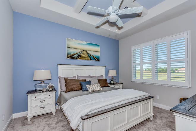 The calming blue and grey color scheme outside carry into the interior of this exquisite home. [Adley Homes]