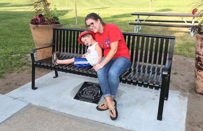 Colton Hall, 4, and his mother Lindsey Hall have their photo taken with the new plaque and bench in memory of Carson Hall at Garden Grove Park Friday, June 14, 2019. [Sandra J. Milburn/HutchNews]