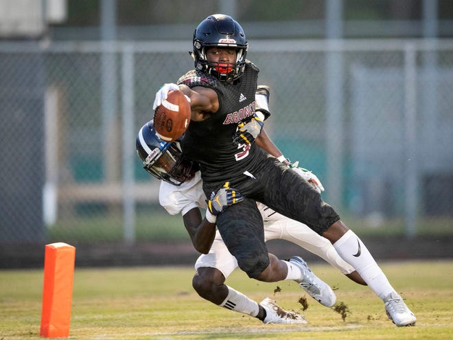 Palm Beach Central wide receiver Bryan Robinson stretches for the end zone but comes up a few yards short as he is tackled by Dwyer's DaQuan Wilson during a game last season. [ALLEN EYESTONE/palmbeachpost.com]