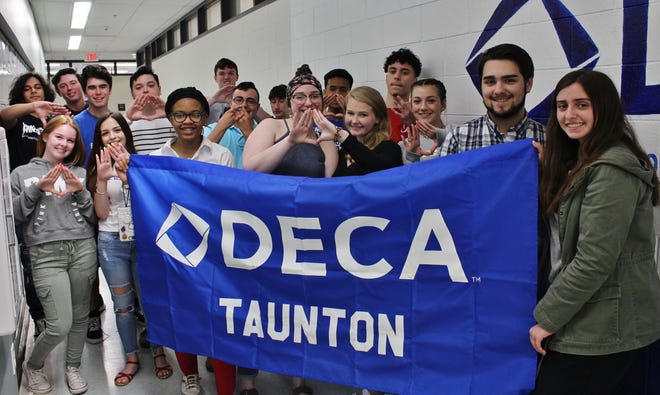 Taunton High School DECA students from one class pose for a photo in front of their classroom. (Back row, from left): Harry Singh, Spencer Andrews, Curtis Higgins, Keegan Hayes, Jack McGonagle, Brett Chaves, Andrew Ially, Shyheim Blue and Nathan Guarino. (Front row, from left): Amanda Weber, Alison Personeni, Naicha Christophe, Riley Patten, Shelby Margie, Morgan Zakrzewski, Kyle Cardoso, and Meaghan DeCouta. (Taunton Gazette photo by Jordan Deschenes)