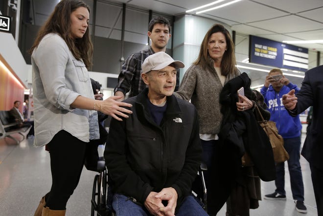 FILE - In this Tuesday, Nov. 22, 2016 file photo former Massachusetts House Speaker Salvatore DiMasi, center, is flanked by stepchildren Ashley, left, Christian, center top, and his wife Debbie, right, while speaking to members of the media as he arrives at Logan International Airport, in Boston. DiMasi, who served five years in prison on federal corruption charges, is appealing a decision that bars him from registering as a Beacon Hill lobbyist, Thursday, June 13. [AP Photo/Steven Senne, File]