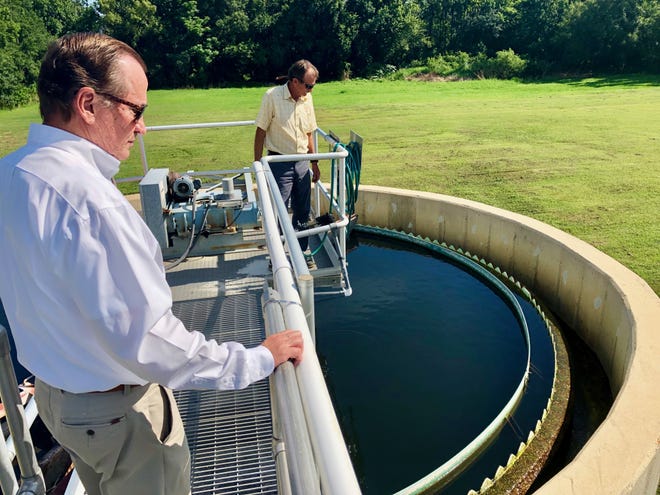 Gordon Smith, St. Johns County Utility Engineering Manager, left, and plant manager Randy Harris look over a wastewater treatment tank at the wastewater treatment plant at the end of North Main Street in Hastings. [TRAVIS GIBSON/THE RECORD]