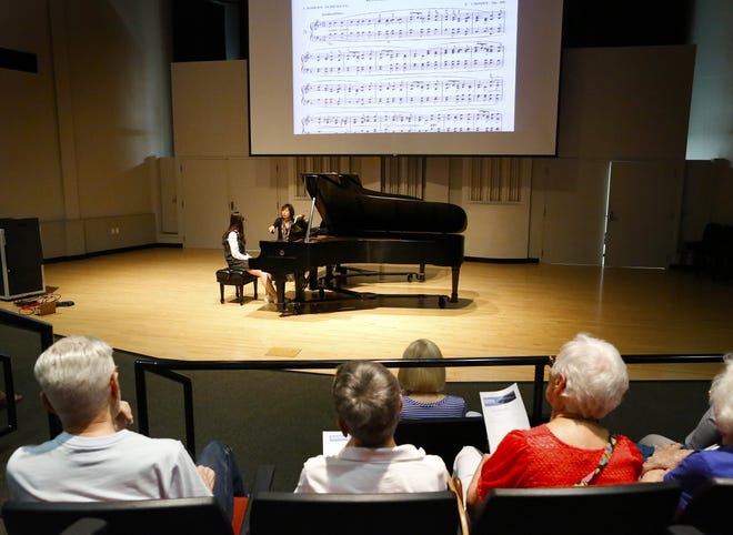 People watch as Jasmin Arakawa, a professor of piano at UF and director of the International Piano Festival, gives direction to But Viet Ha as part of a master class on Saturday during the IPF at the University of Florida School of Music in Gainesville. [Staff photos by Brad McClenny]