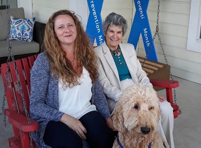 County Commissioner Terry Cook visits with Kerrie Stannell, CEO of the Williamson County Children's Advocacy Center. They are joined by Charlie, the goldendoodle who calms children with his peaceful and affectionate nature. [Courtesy photo]