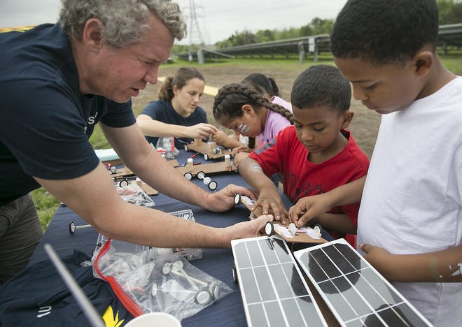 Stan Pipkin, with Solar Austin, helps brothers Nasaiah Thompson, 5 center, and Willie Thompson, 8, right, build solar cars for racing. Austin Energy, the City of Austin?'s electric utility, recently began receiving solar energy from its La Loma Community Solar Farm in East Austin. The project is the largest community solar farm in the Electric Reliability Council of Texas (ERCOT) and the first in Texas to offer low-income customers a discounted rate celebrated the Grand Opening of La Loma at a Community Solabration Saturday mooring March 24, 2018.

RALPH BARRERA / AMERICAN-STATESMAN