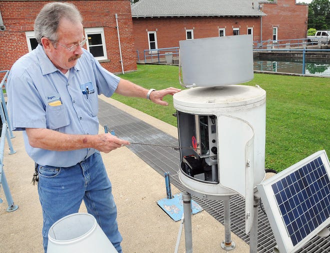Roger Lyons shows the electronics of the National Weather Service rain gauge at the Cambridge Water Plant.