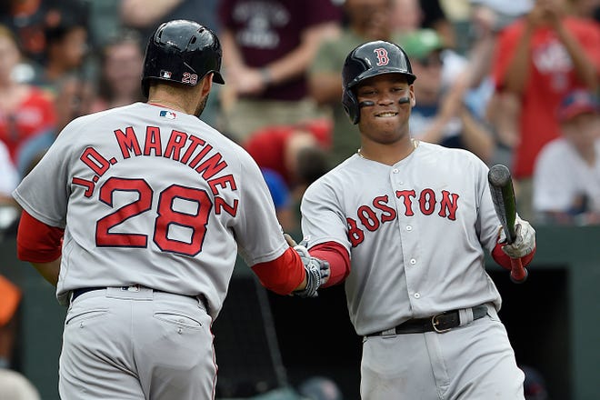 Boston Red Sox's Rafael Devers, right, congratulated J.D. Martinez after his solo home run against the Baltimore Orioles in the seventh inning of a baseball game Saturday, June 15, 2019, in Baltimore. (AP Photo/Gail Burton)