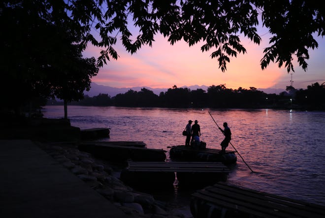 A raft operator pushes away from shore ferrying passengers to the Guatemalan side, in Ciudad Hidalgo, Mexico, at sunrise on Tuesday, June 18, 2019. The number of migrants taking rafts at the busy Ciudad Hidalgo crossing point appears to have decreased significantly in recent days amid fears of a pending deployment of the National Guard along the southern border. [REBECCA BLACKWELL/THE ASSOCIATED PRESS]