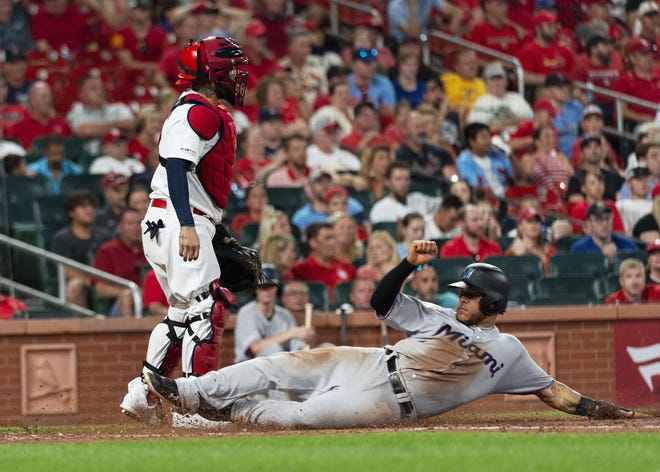 The Miami Marlins' Harold Ramirez slides safely into home next to St. Louis Cardinals catcher Yadier Molina during the eighth inning Tuesday in St. Louis. [L.G. PATTERSON/THE ASSOCIATED PRESS]