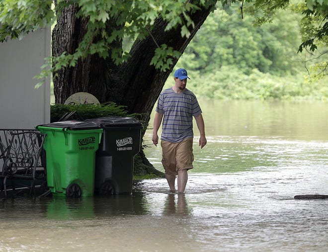 Chris Murphy of Clinton surveys flooding around his home in the 7700 block of Main Street on Monday. The Tuscarawas River crested its banks due to heavy rain.

(GateHouse Media Ohio / Kevin Whitlock)