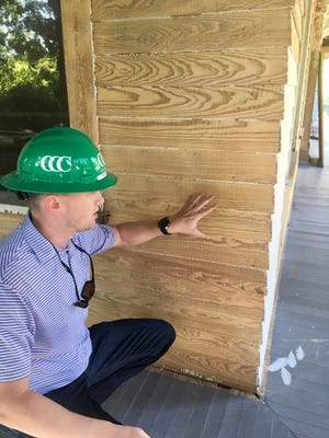 Brandon Klein shows the saw marks on the planks of the home's exterior. [SAMANTHA SWANN/SPARTANBURG HERALD-JOURNAL]