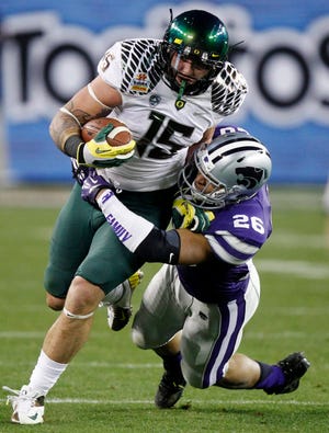 Oregon tight end Colt Lyerla (15) is tackled by Kansas State linebacker Jarell Childs during the second half of the Fiesta Bowl on Jan. 3, 2013, in Glendale, Ariz. [AP Photo/Paul Connors]