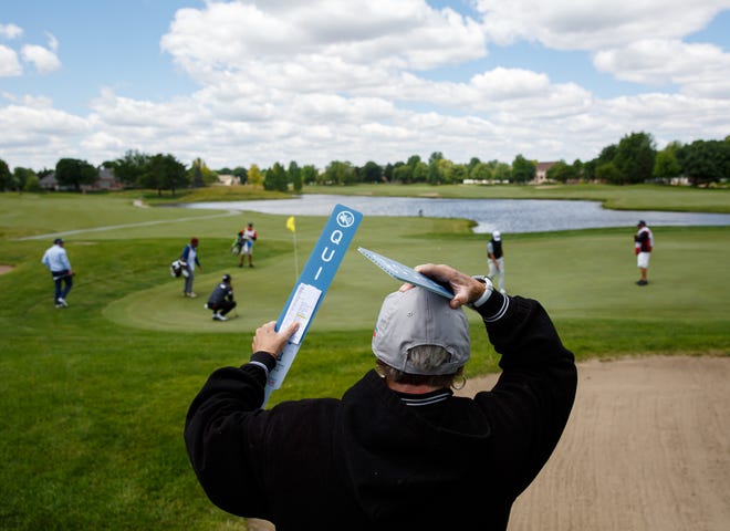 Volunteer Judy Greenan holds on to her hat as the wind gusts around the No. 9 hole Thursday during the opening round of the Lincoln Land Championship Presented by LRS at Panther Creek Country Club. [Justin L. Fowler/The State Journal-Register]
