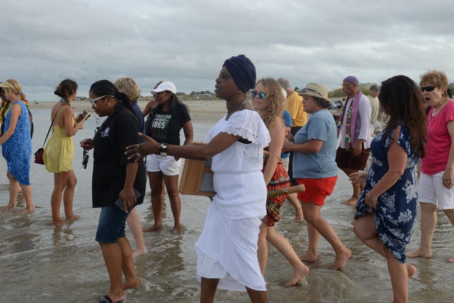 A member of Patt Gunn's entourage, The Saltwata Players, leads the crowd that came for the Wade-In into the waters of Tybee's beach. [Tandra Smith/Savannahnow.com]