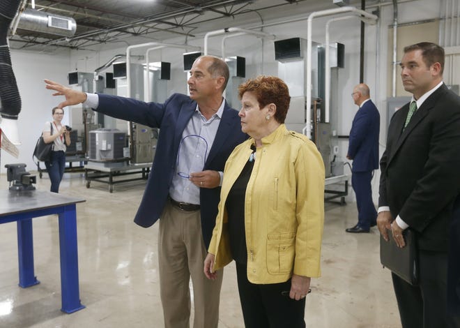 Chris Martin, president and owner of The K Company, gives a tour to Summit County Executive Ilene Shapiro, Barberton Mayor Bill Judge and others after a news conference Thursday in Akron. [Phil Masturzo/Beacon Journal/Ohio.com]
