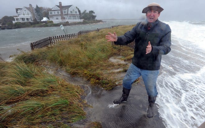 Greg Berman, of Woods Hole Sea Grant, stands next to a cut at Popponesset Beach in Mashpee during a 2012 storm. The Cape has experienced 11 inches of sea rise since 1922, Berman said Wednesday. [Ron Schloerb/Cape Cod Times file]
