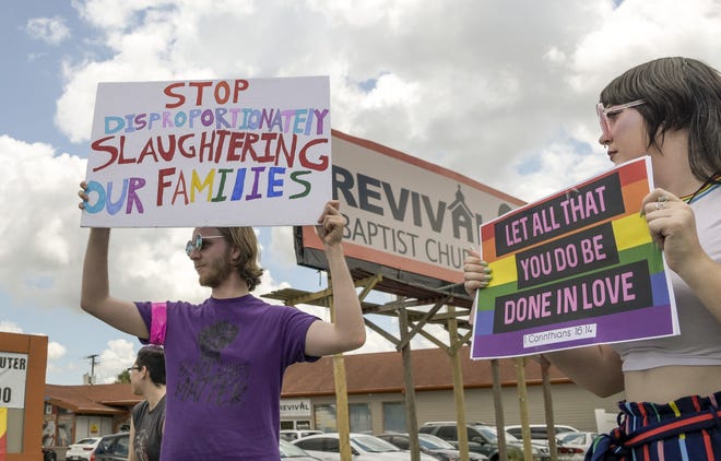 Protesters hold up signs outside the Revival Baptist Church in the Four Corners area of Clermont on Saturday. More than 100 people opposed the anti-gay message of its "Make America Straight Again" conference this weekend. [Paul Ryan/Correspondent]