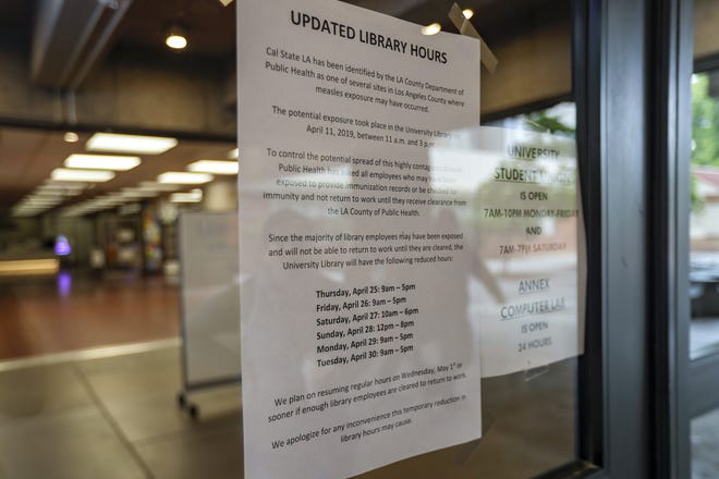 A sign posted by the Los Angeles County Department of Health at California State University in Los Angeles warns visitors about possible measles exposure at the campus library. A person with a confirmed measles case visited the library on April 11. Seventy-one students and 127 staff members were quarantined following the incident. (Irfan Khan/Los Angeles Times/TNS)