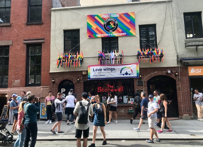 Tourists mill around New York's Stonewall Inn, the dive bar that was the site of street clashes in 1969 that helped launch the gay rights movement. [Rick Holmes]