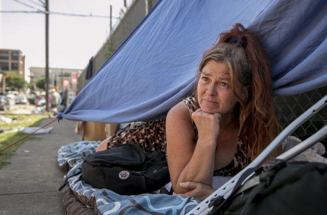 Shannon Sorgman, who is homeless, rests under a makeshift shelter on the sidewalk on Neches Street last month. Early Friday, the Austin City Council voted to ease restrictions against public camping in Austin. [JAY JANNER/AMERICAN-STATESMAN]