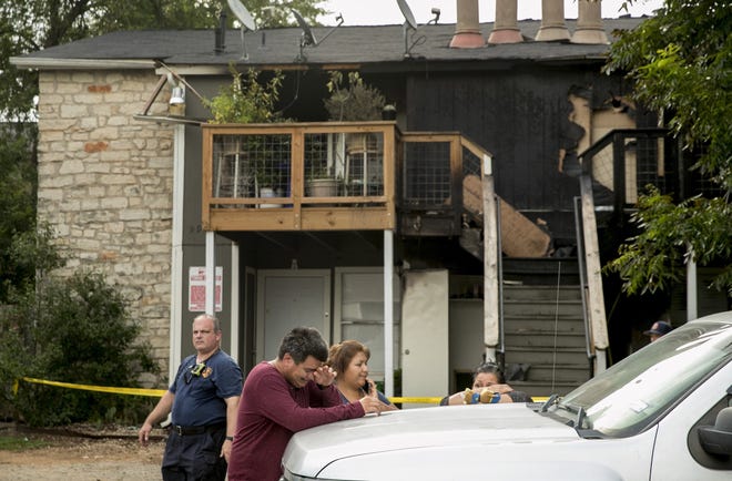 Ramon Galvan stands outside his apartment on Roxanna Drive with his sister-in-law Consuela Negrete, middle, and his wife Magdalena De Jesus after a fire Friday. There were no injuries, but 19 residents were displaced. [JAY JANNER/AMERICAN-STATESMAN]
