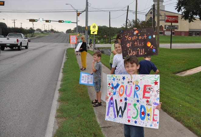 The Pflugerville Public Library helped organize a Kindness Rally in October, where both children and adults held inspirational signs on Pecan Street for commuters heading to work and school. [Courtesy photo]